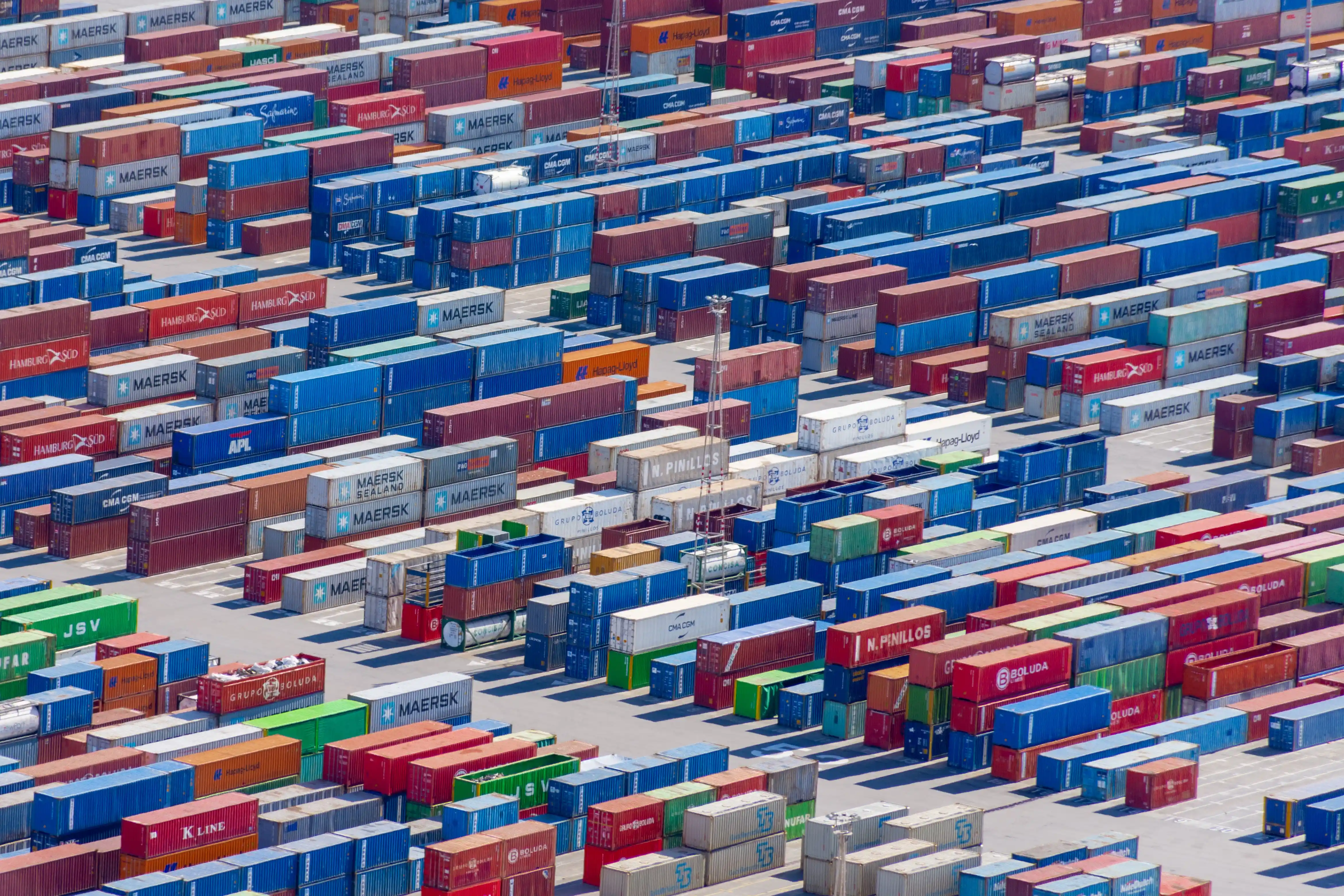 Multiple containers in various colours stacked over a large area
