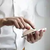 man in white shirt holding a phone
